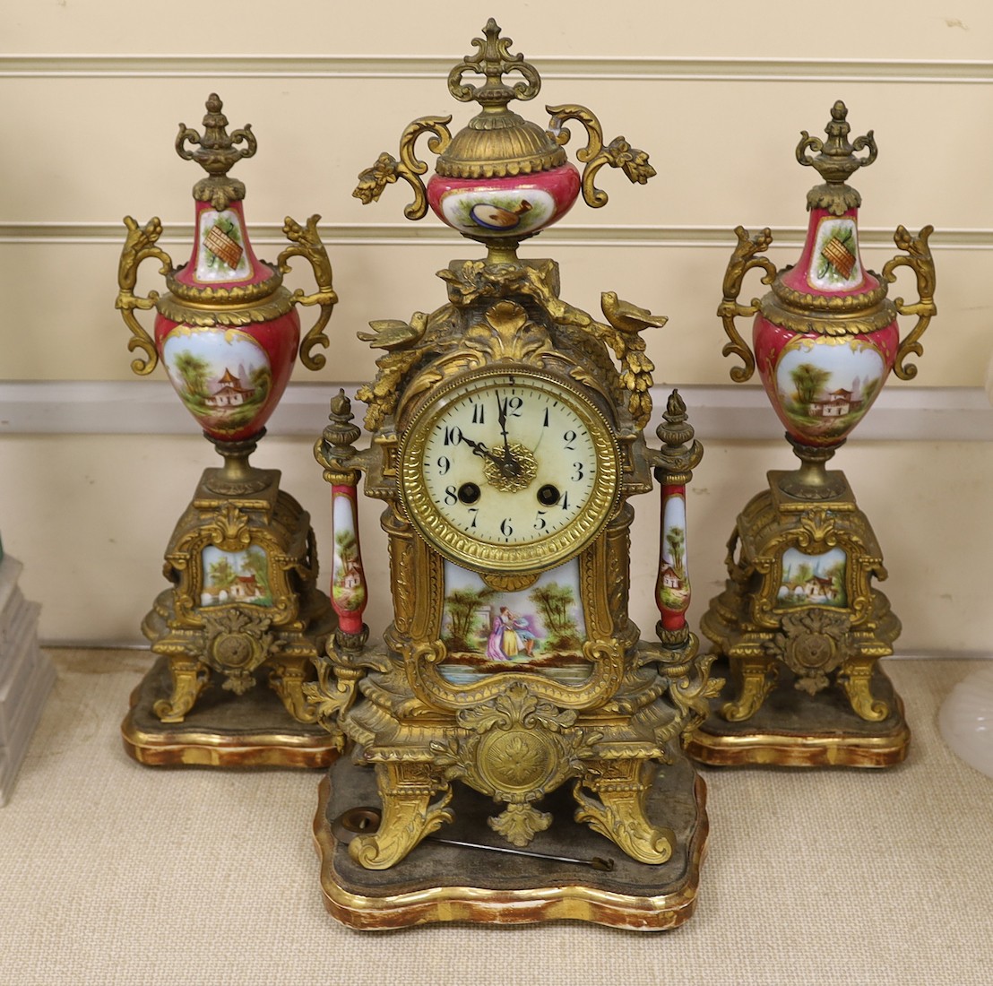 A 19th century Louis XV style gilt metal and porcelain mounted three piece clock garniture, clock 45cms high